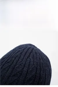 Close-up of navy blue winter knit hat showing thick ribbed texture and warm lining