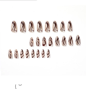 Flat lay of 24 almond nails with champagne gold glitter and brown wavy swirl patterns