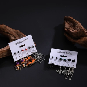 Halloween earring set featuring pumpkin skull and bat designs on a dark rustic background