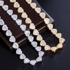 Close-up of iced-out heart cuban necklaces with zircon pavé in gold and silver finish