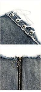 Dettaglio degli shorts in denim blu con occhielli argento, lacci laterali e zip con anello