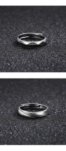 Close-up of silver rings with geometric facets and brushed texture on black sand