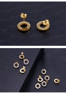 Macro shot of gold circular earrings with crystal diamond inlay on black leather