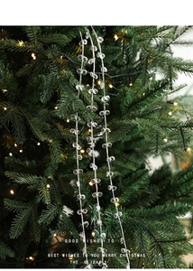 Gros plan de guirlandes de perles de cristal acrylique sur une branche de sapin de Noël