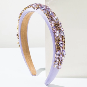 Détail d'un serre-tête violet rembourré avec strass floraux et chaînes dorées élégantes
