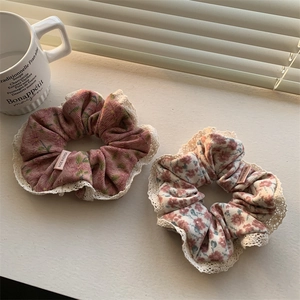 Detail of floral lace scrunchies in pink and beige fabric with Made in Korea labels