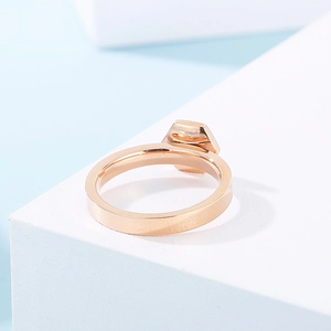Close-up of a rose gold hexagonal titanium ring with rhinestones on a geometric block