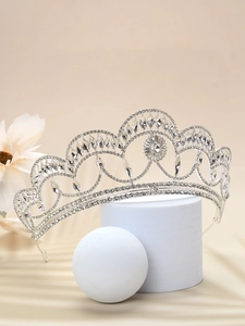 Close-up of vintage silver bridal crown with crystals on elegant beige floral background