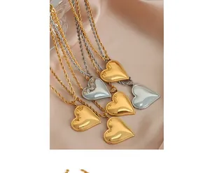 Makroaufnahme von Herzanhängern in Gold und Silber mit Seilketten auf Seide