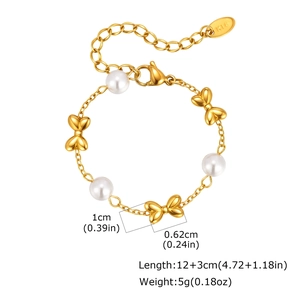 Detail of girls gold pearl bracelet with bow accents and K18 hallmark engraving