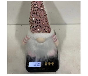 Detail of pink sequin Christmas gnome doll showing weight of 84.0g on digital scale