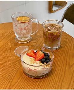 Vue détaillée d'un ensemble en verre avec motifs floraux roses et nœuds sur bois