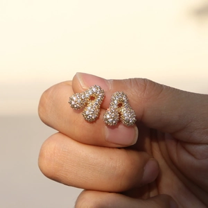 Close-up of gold plated brass balloon letter A stud earring with pavé zircon stones