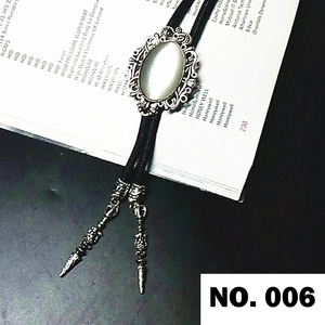 Detail of silver western bolo tie with white opal stone and ornate metal tips