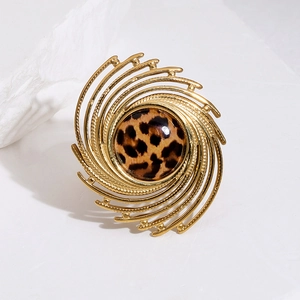 Dettaglio macro dell'anello a spirale dorato con intarsio centrale in pietra leopardata