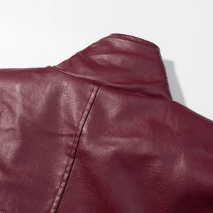 Close-up of burgundy faux leather texture and shoulder stitching on a jacket