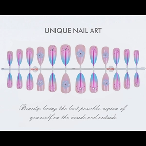Detail of short almond press-on nails with floral patterns and pink to blue gradient finish
