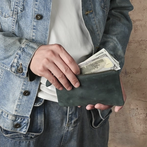 Retro slim dark green crazy horse leather clutch wallet held by a model in denim