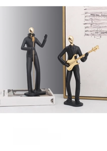 Close-up of abstract black and gold resin music sculpture with singer and guitarist