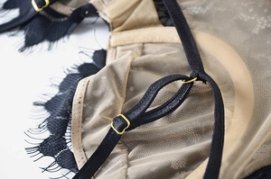 Macro shot of black eyelash lace trim and adjustable golden hardware on the bra strap