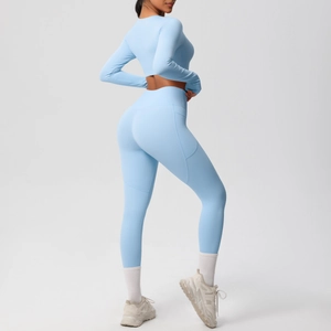 Close-up of light blue yoga set featuring a long sleeve crop top and high-waist side pocket leggings