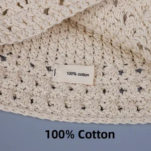 Close-up of the 100% cotton composition label on a white crochet knit bucket hat