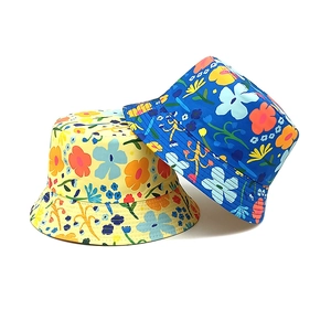 Detail of yellow and blue kids bucket hats with vibrant floral and cartoon patterns