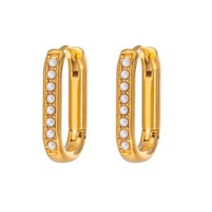 Detailed close-up of U-shaped gold earrings with embedded white pearls on white background