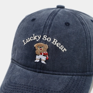 Detailed close-up of teddy bear embroidery and Lucky lettering on a navy baseball cap