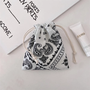 Detail of drawstring storage bag with classic black paisley pattern on soft cotton fabric