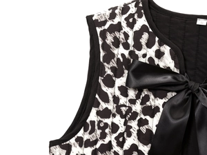 Detail of leopard print quilted vest featuring black satin bow tie and size S label