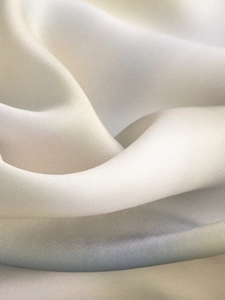Close-up of soft beige satin fabric showing smooth texture and elegant silky luster