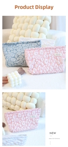 Detail of pink embossed cloud makeup bag with 3D texture and gold metal zipper