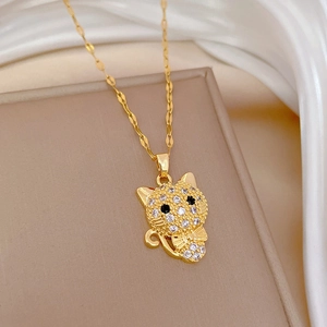 Detailed view of luxury cat pendant with glittering zircons on gold chain over silk