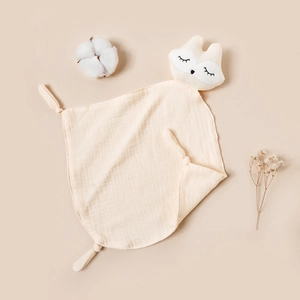 Detail of baby muslin comforter in cream yellow with fox head and soft cotton texture