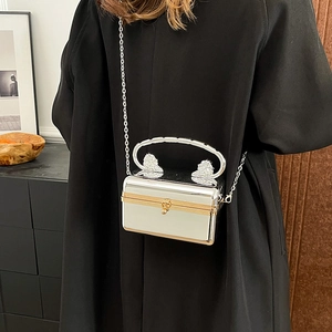 Silver metallic acrylic box bag with vintage telephone handle and gold chain strap