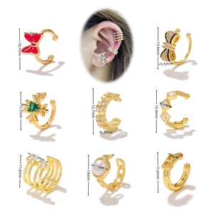 Set of eight gold ear cuffs featuring zircon bow knots, pearls, and crosses with measurements
