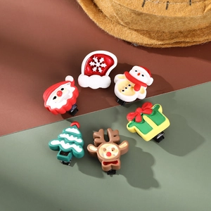 Close-up of six colorful resin Christmas hair clips with Santa and reindeer designs