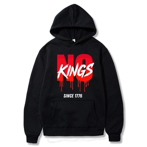 Detail of black Christmas hoodie featuring No Kings Since 1776 print and kangaroo pocket