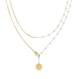 Double-layer gold chain necklace with pearls and round pendant on white background