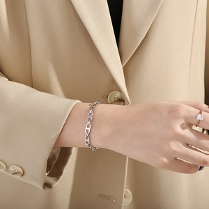 Minimalist silver stainless steel link bracelet shown on a model's wrist in a sleek style
