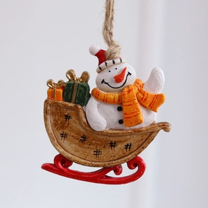 Festive resin snowman on a sled Christmas tree hanging ornament with colorful accents