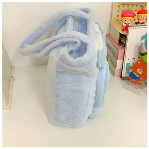 Macro shot of light blue plush handbag featuring Cinnamoroll character detail and zipper