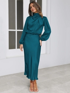 Detail of teal satin halter midi dress featuring a cowl neck and elegant glossy texture