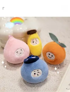Close-up of four cute fruit plush pendants with embroidery on a soft beige carpet