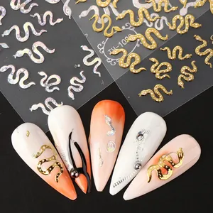 Macro detail of metallic gold and laser silver snake nail art stickers on French nails