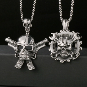 Macro detail of gothic skull pendants with crossed pistols and wrench in steel finish