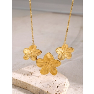 Macro detail of 18k gold-plated stainless steel necklace with three floral pendants