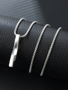 Macro shot of silver titanium steel rectangular bar pendant on a box chain necklace