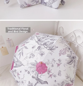 Detailed close-up of a white umbrella featuring vintage bird and floral prints with text